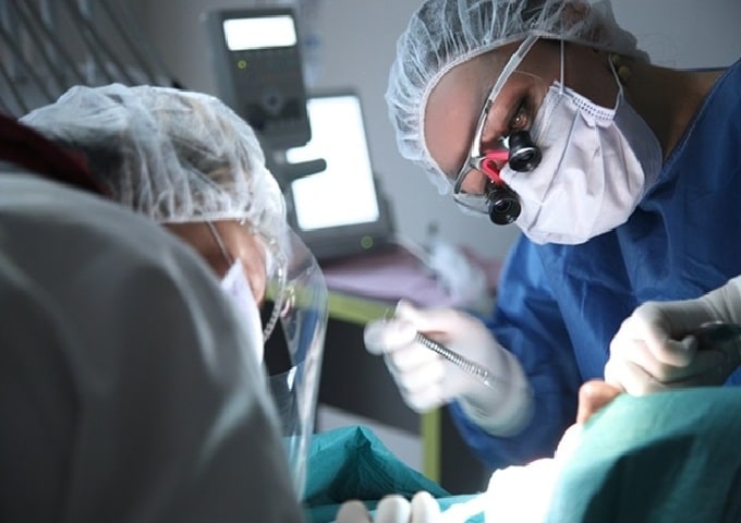 two iranian dentist performing dental procedure on patient