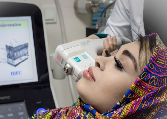 an iranian woman lying at ease while getting ultherapy treatment in iran in a modern clinic