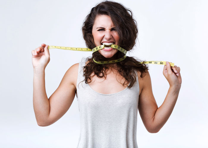 woman with a measuring tape tied around neck