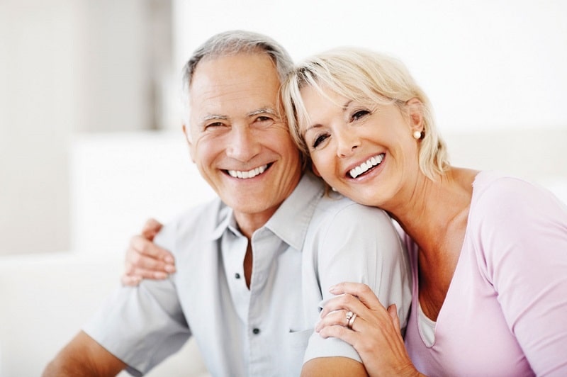 happy old couple with dentures ans bright smiles 