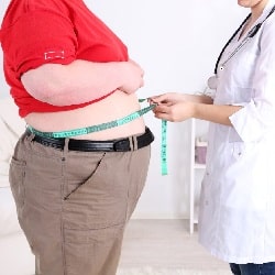 doctor measuring waistline of obese man
