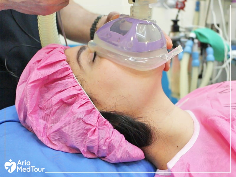 patient wearing pink clothes getting general anesthetics via a mask before suregry