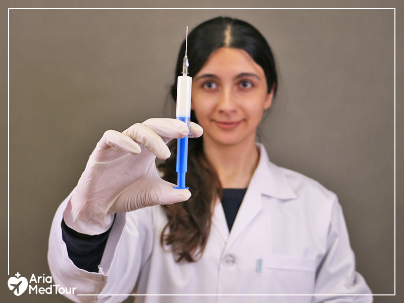 a young female anesthetist holding a syringe for administering